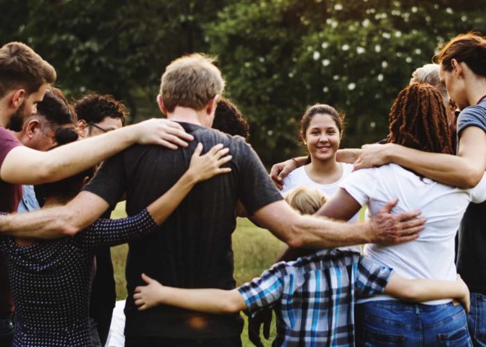 Group of people huddle together in the park Group of people huddle together in the park