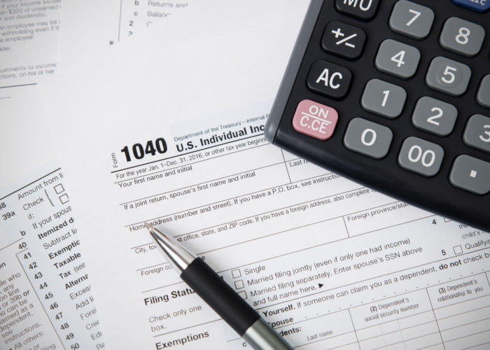 US tax form 1040 with pen and calculator US tax form 1040 with pen and calculator