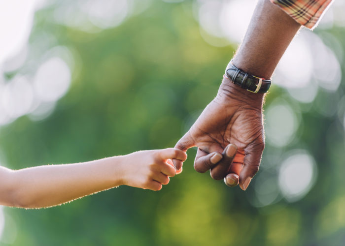cropped view of african american grandfather holding hands with little granddaughter cropped view of african american grandfather holding hands with little granddaughter